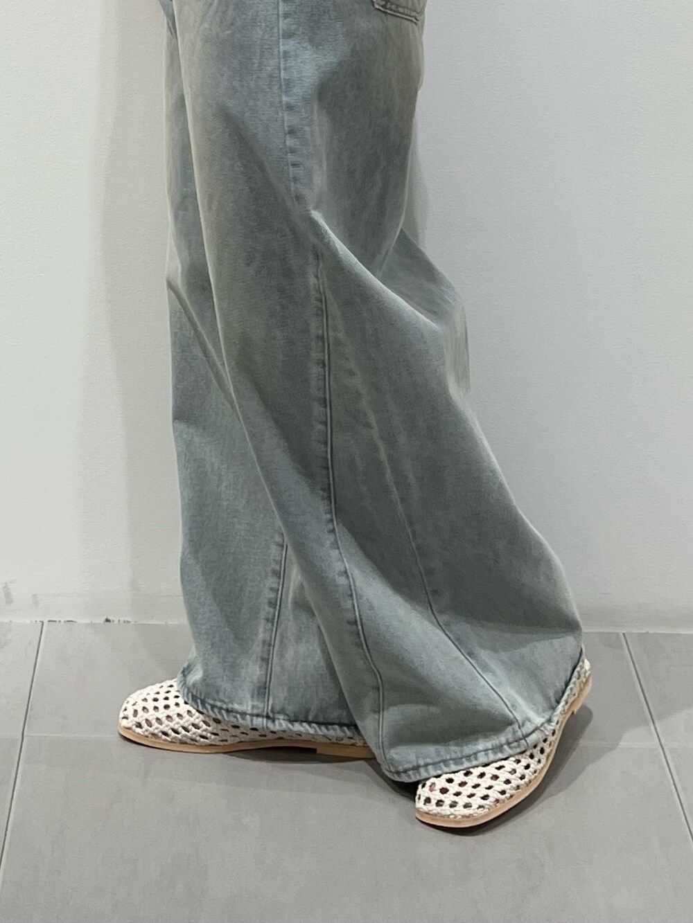 ブルー系のデニムパンツ、ホワイト系のカーディガン/ボレロ、ホワイト系のサンダルを着用したレディースの春コーディネートの4枚目の写真