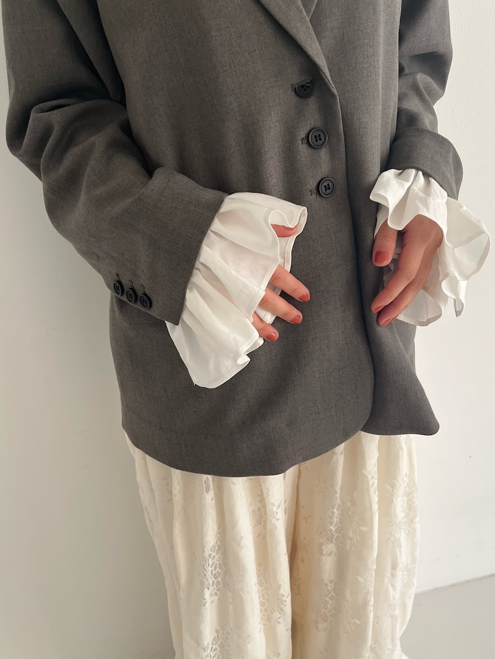 ブラック系のパンプス、グレー系のその他アウター、ホワイト系のその他パンツを着用したレディースの冬コーディネートの5枚目の写真