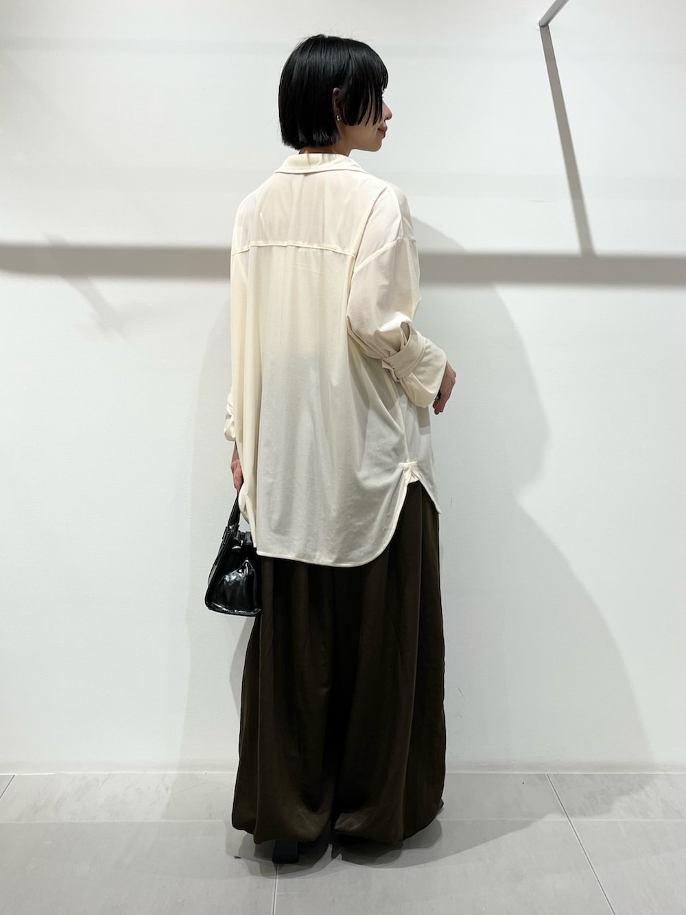 ブラック系のボストンバッグ、ホワイト系のシャツ/ブラウス、ブラック系のパンプスを着用したレディースの冬コーディネートの4枚目の写真