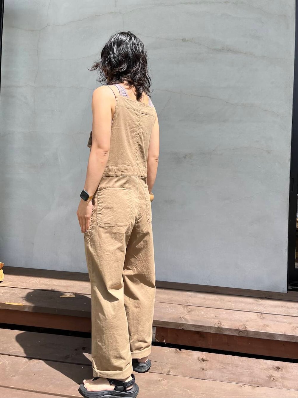 イエロー系のサロペット/オーバーオール、ブラック系のサンダルを着用したレディースの夏コーディネートの3枚目の写真