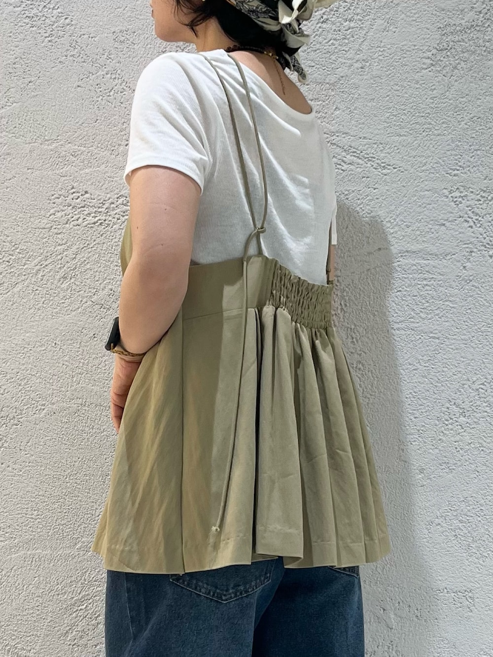 ブラック系のサンダル、ホワイト系のTシャツ/カットソー、ブルー系のデニムパンツを着用したレディースの夏コーディネートの6枚目の写真