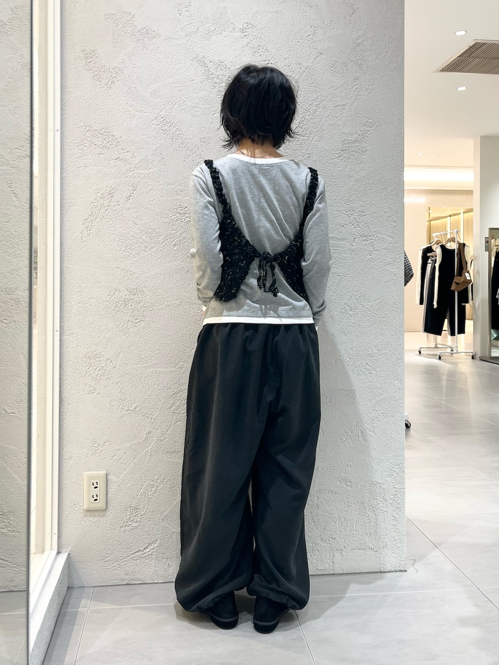 グレー系のTシャツ/カットソー、ブラック系のニット/セーター、グレー系のその他パンツを着用したレディースの秋コーディネートの3枚目の写真