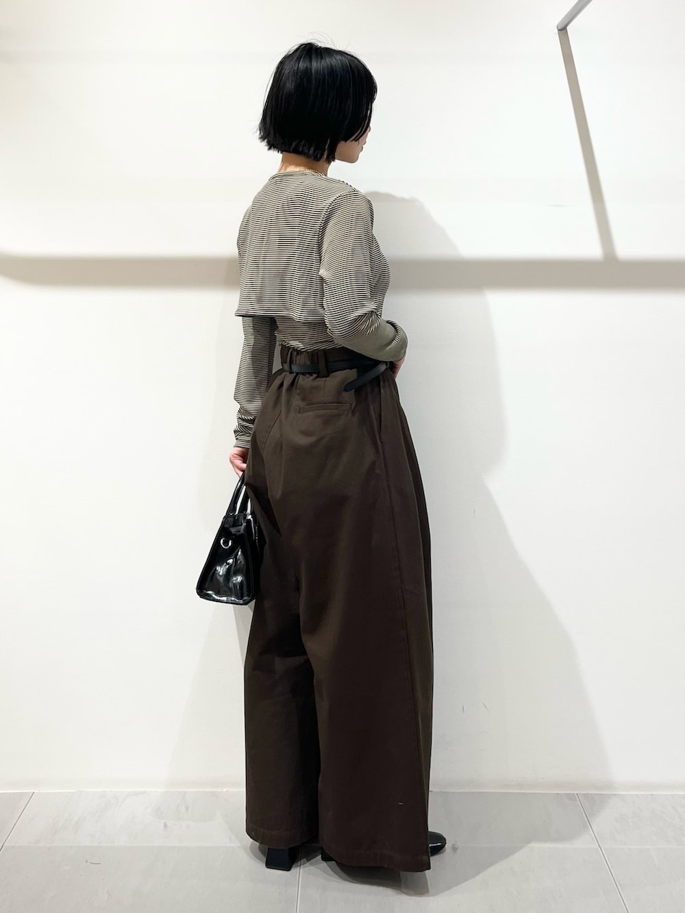 ベージュ系のキャミソール、ブラウン系のその他パンツ、ブラック系のボストンバッグを着用したレディースの春コーディネートの4枚目の写真