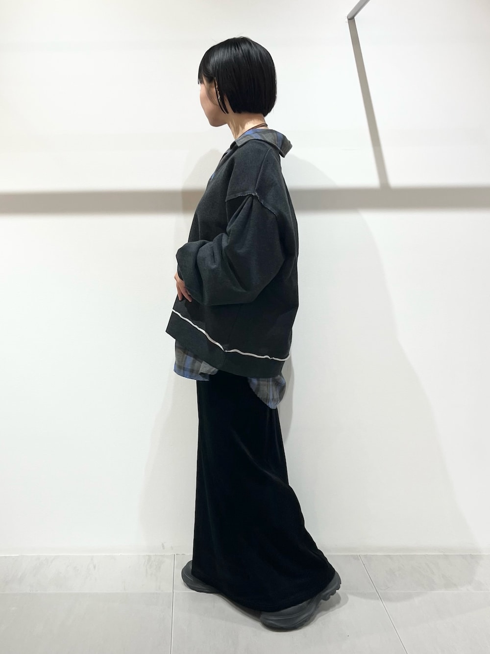 ブルー系のシャツ/ブラウス、ブラック系のスカート、ブラック系のブーツを着用したレディースの秋コーディネートの2枚目の写真