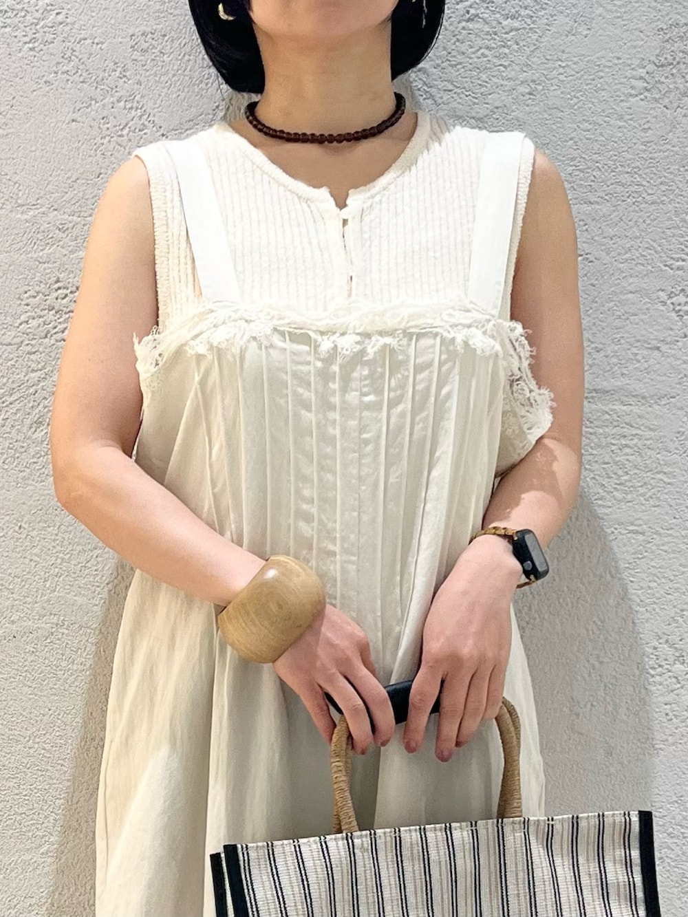 ホワイト系のその他パンツ、ブラック系のトートバッグ、ブラック系のサンダルを着用したレディースの夏コーディネートの4枚目の写真