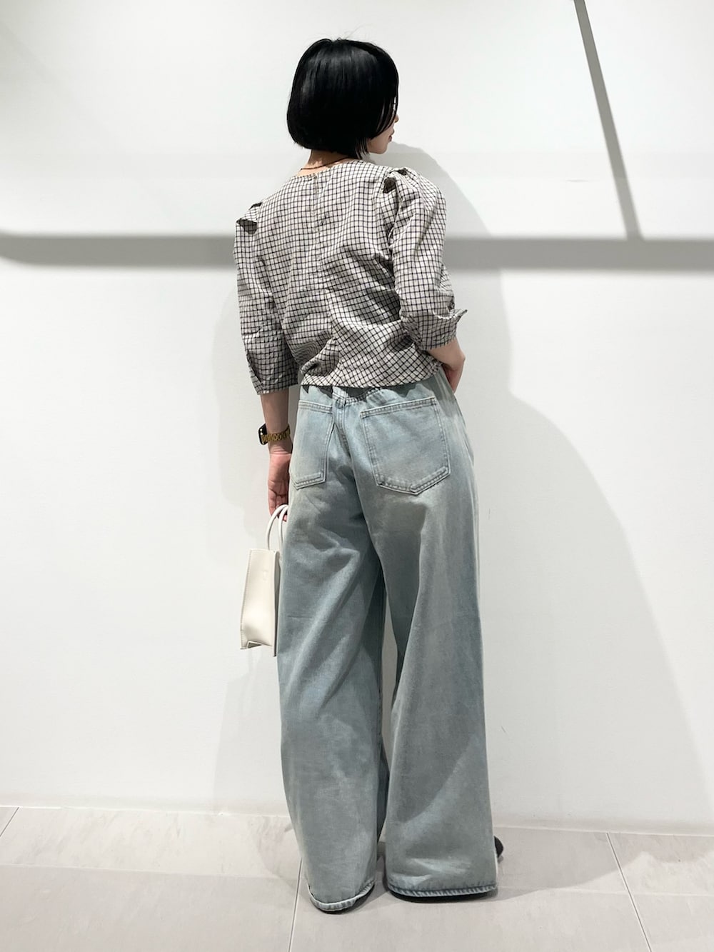 ベージュ系のシャツ/ブラウス、ブルー系のデニムパンツ、ブラック系のその他シューズを着用したレディースの春コーディネートの3枚目の写真