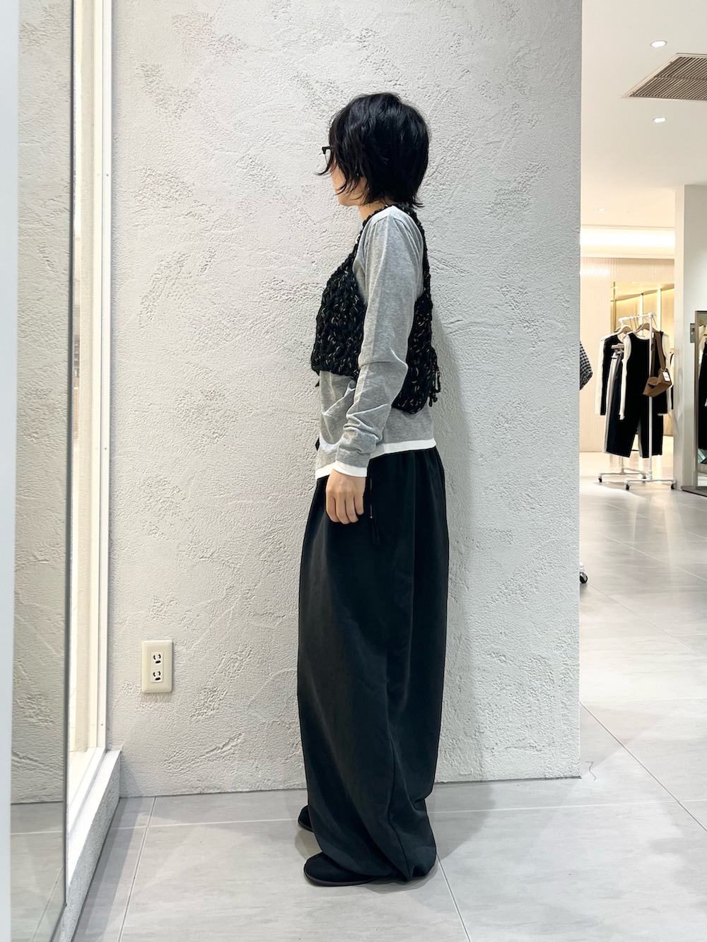 グレー系のTシャツ/カットソー、ブラック系のニット/セーター、グレー系のその他パンツを着用したレディースの秋コーディネートの2枚目の写真