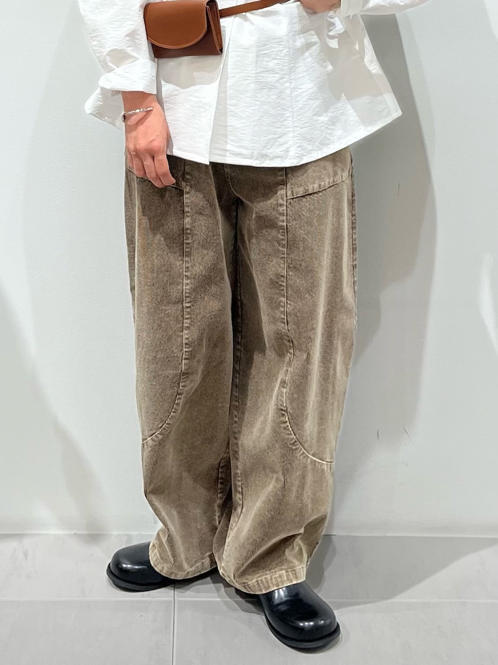 ブラック系のその他シューズ、ブラウン系のその他パンツ、ホワイト系のシャツ/ブラウスを着用したレディースの秋コーディネートの5枚目の写真