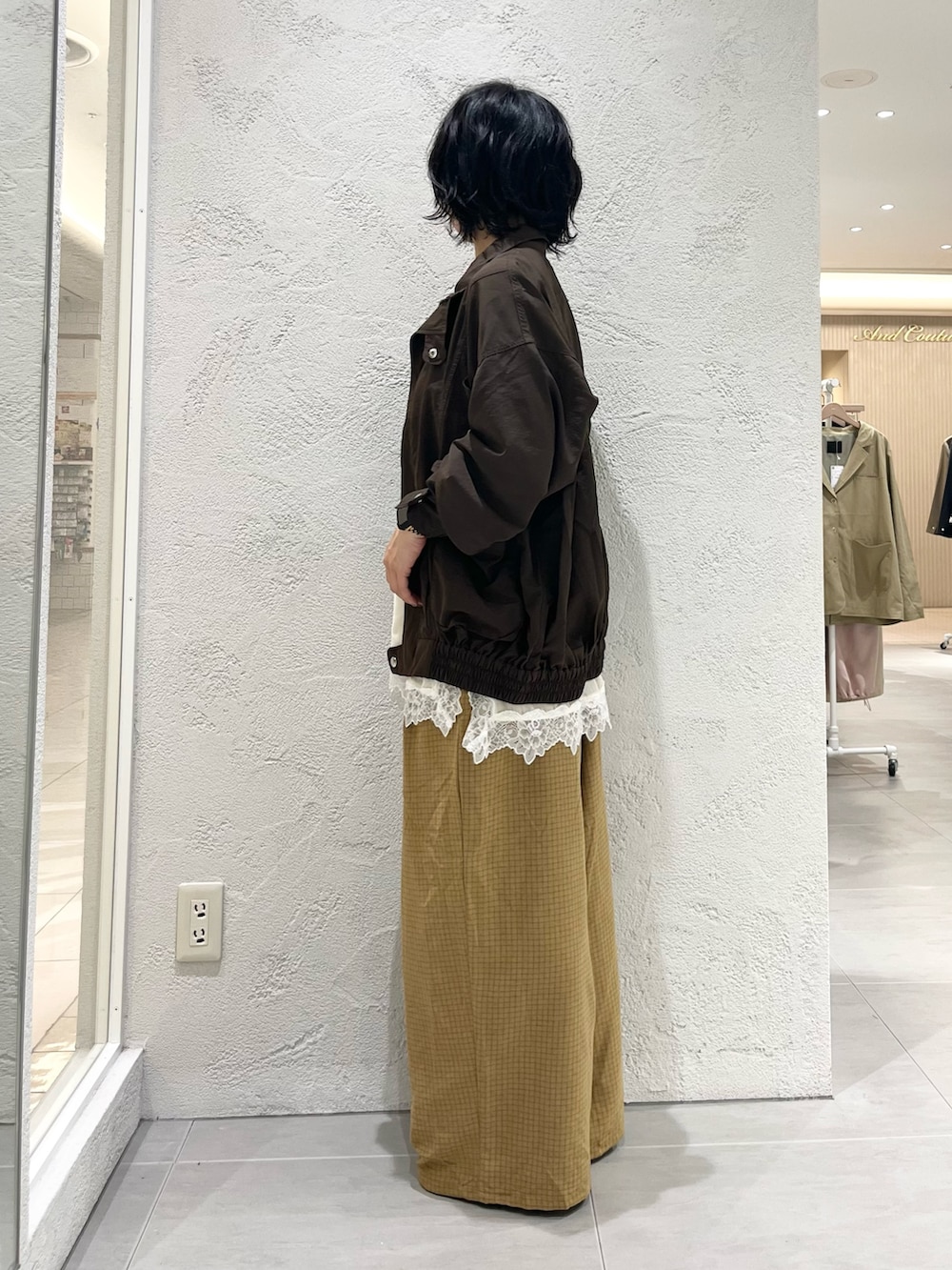 ブラック系のサンダル、イエロー系のその他パンツ、ブラウン系のナイロンジャケットを着用したレディースの秋コーディネートの2枚目の写真