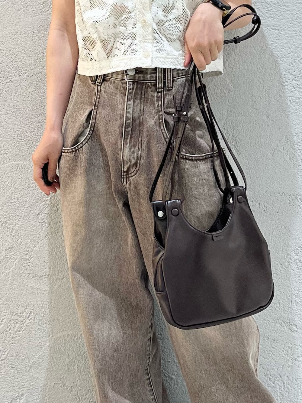 ブラウン系のショルダーバッグ、ホワイト系のシャツ/ブラウス、ブラウン系のデニムパンツを着用したレディースの夏コーディネートの5枚目の写真