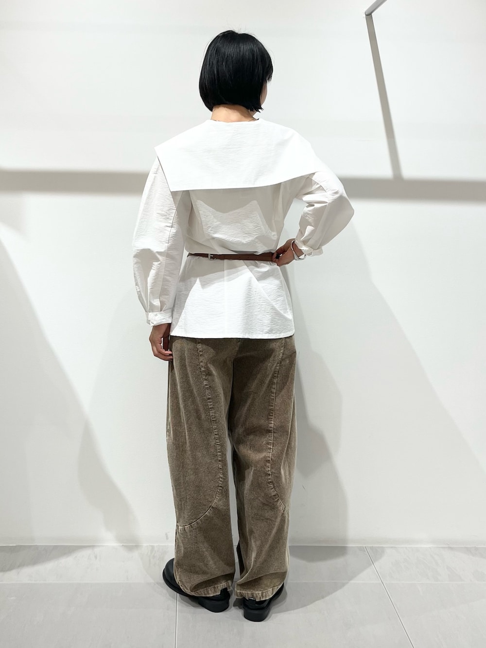ブラック系のその他シューズ、ブラウン系のその他パンツ、ホワイト系のシャツ/ブラウスを着用したレディースの秋コーディネートの4枚目の写真