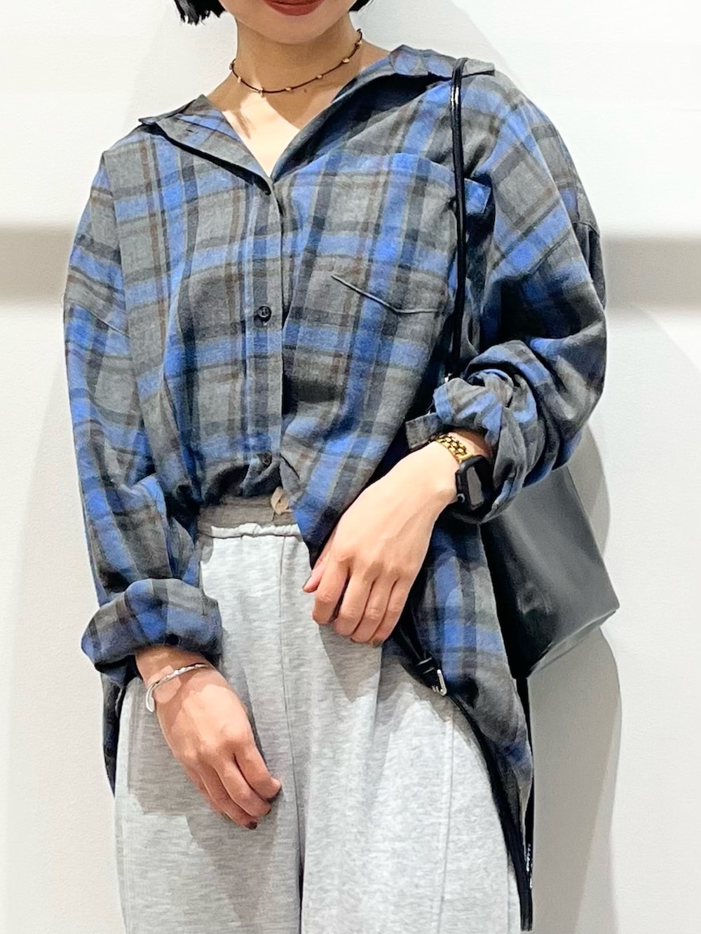 ブルー系のシャツ/ブラウス、ブラック系のショルダーバッグ、ブラック系のブーツを着用したレディースの秋コーディネートの6枚目の写真