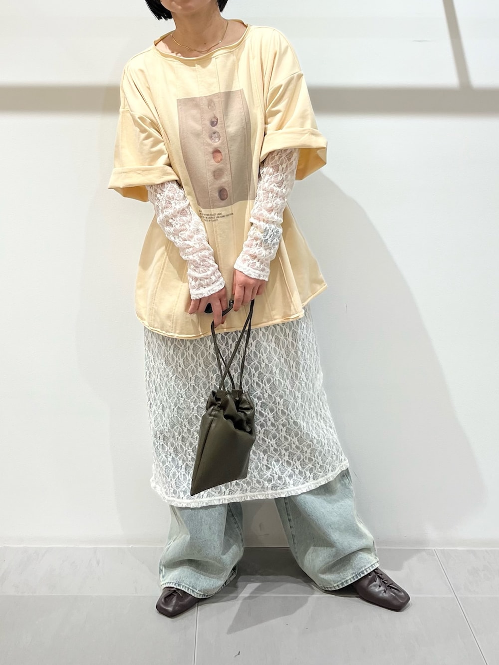 イエロー系のTシャツ/カットソー、ホワイト系のワンピース、グリーン系のショルダーバッグを着用したレディースの春コーディネートの5枚目の写真