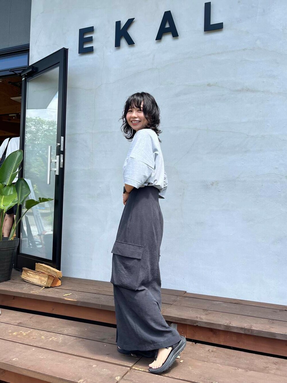 グレー系のTシャツ/カットソー、ブラック系のサンダルを着用したレディースの夏コーディネートの3枚目の写真