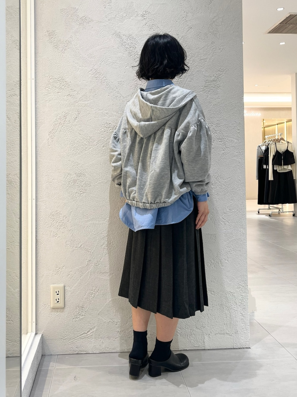 グレー系のスカート、グレー系のパーカー、ブルー系のワンピースを着用したレディースの秋コーディネートの2枚目の写真