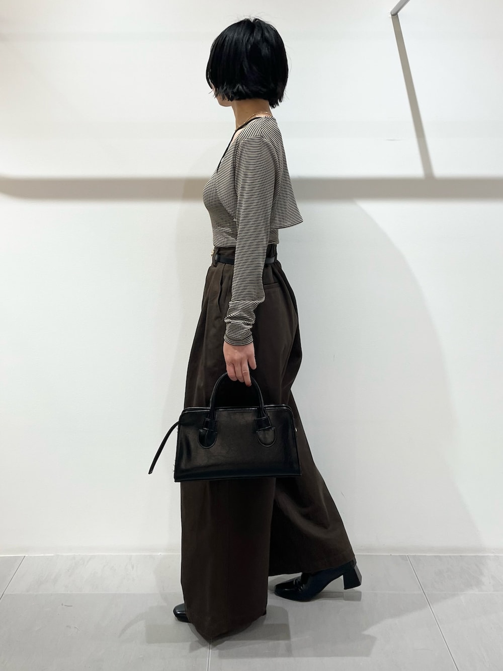 ベージュ系のキャミソール、ブラウン系のその他パンツ、ブラック系のボストンバッグを着用したレディースの春コーディネートの2枚目の写真