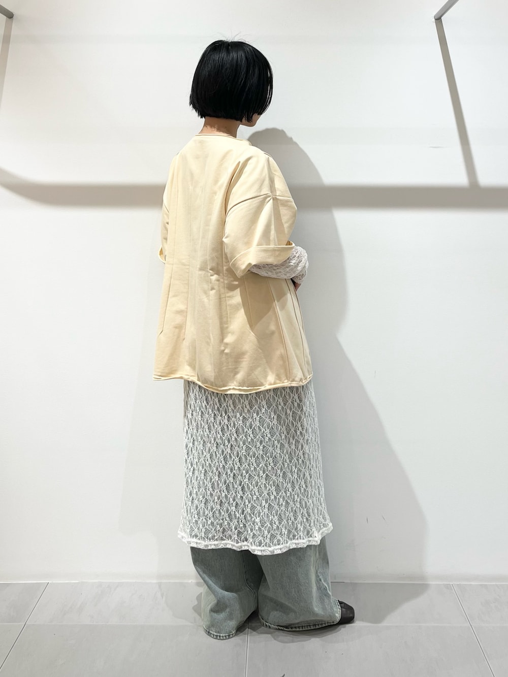 イエロー系のTシャツ/カットソー、ホワイト系のワンピース、グリーン系のショルダーバッグを着用したレディースの春コーディネートの3枚目の写真