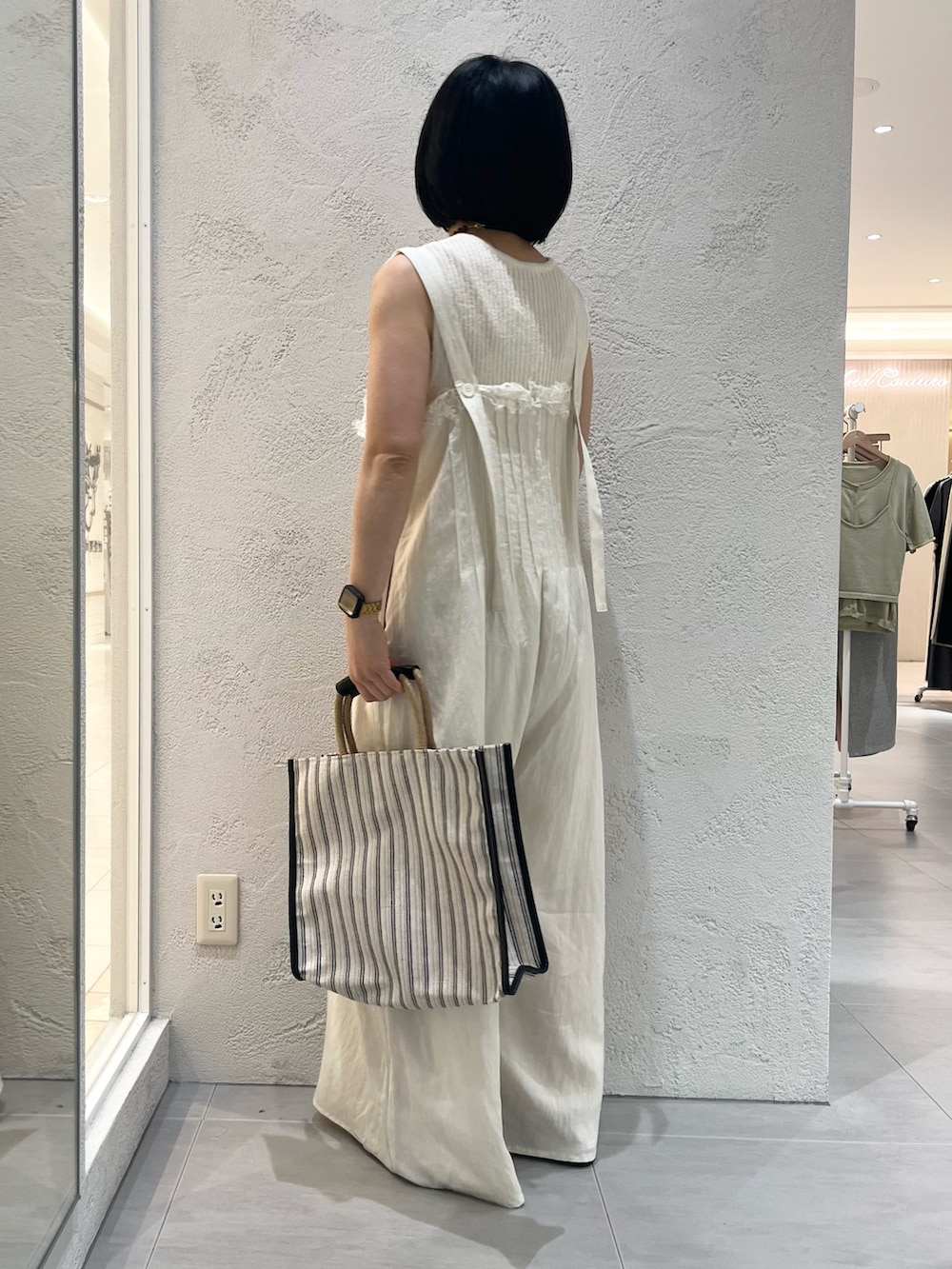 ホワイト系のその他パンツ、ブラック系のトートバッグ、ブラック系のサンダルを着用したレディースの夏コーディネートの3枚目の写真