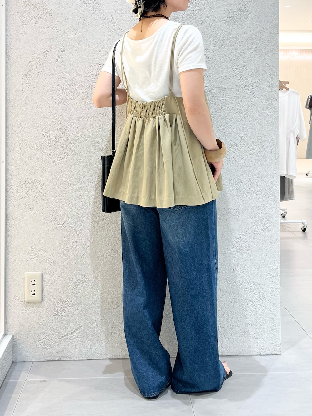 ブラック系のサンダル、ホワイト系のTシャツ/カットソー、ブルー系のデニムパンツを着用したレディースの夏コーディネートの8枚目の写真