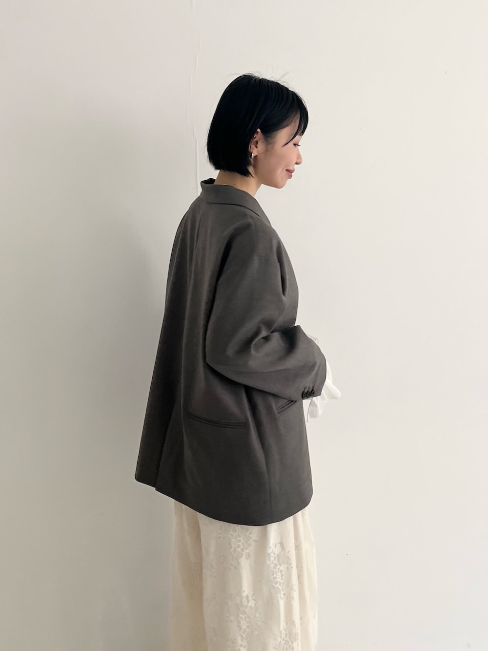 ブラック系のパンプス、グレー系のその他アウター、ホワイト系のその他パンツを着用したレディースの冬コーディネートの2枚目の写真