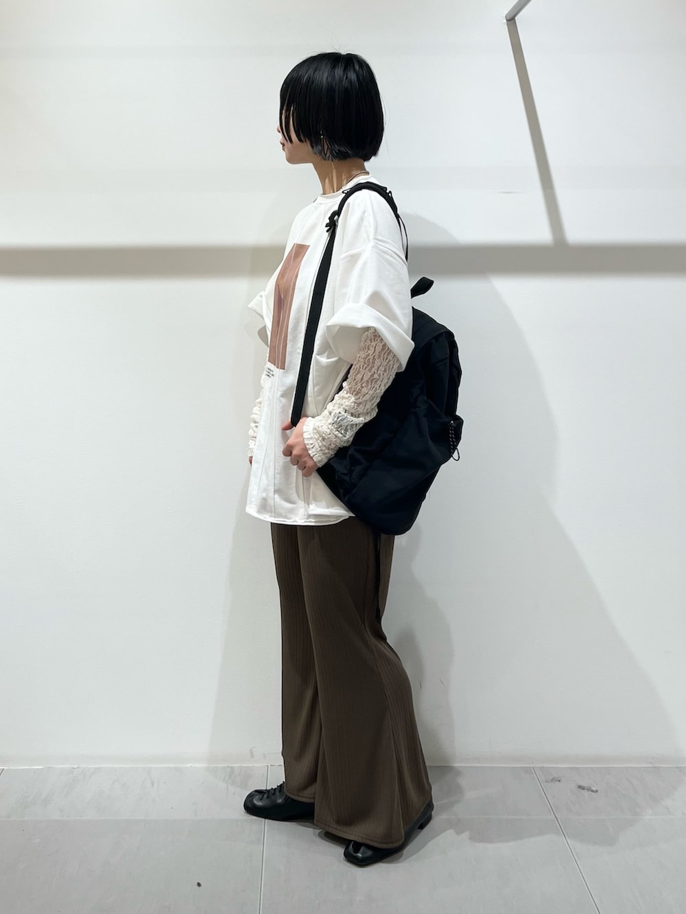 ホワイト系のTシャツ/カットソー、ブラック系のその他シューズ、ブラック系のバックパック/リュックを着用したレディースの春コーディネートの2枚目の写真