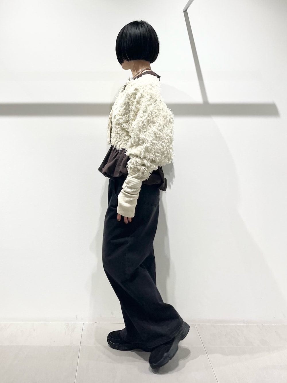 ホワイト系のカーディガン/ボレロ、ブラウン系のTシャツ/カットソー、ブラック系のその他シューズを着用したレディースの冬コーディネートの2枚目の写真