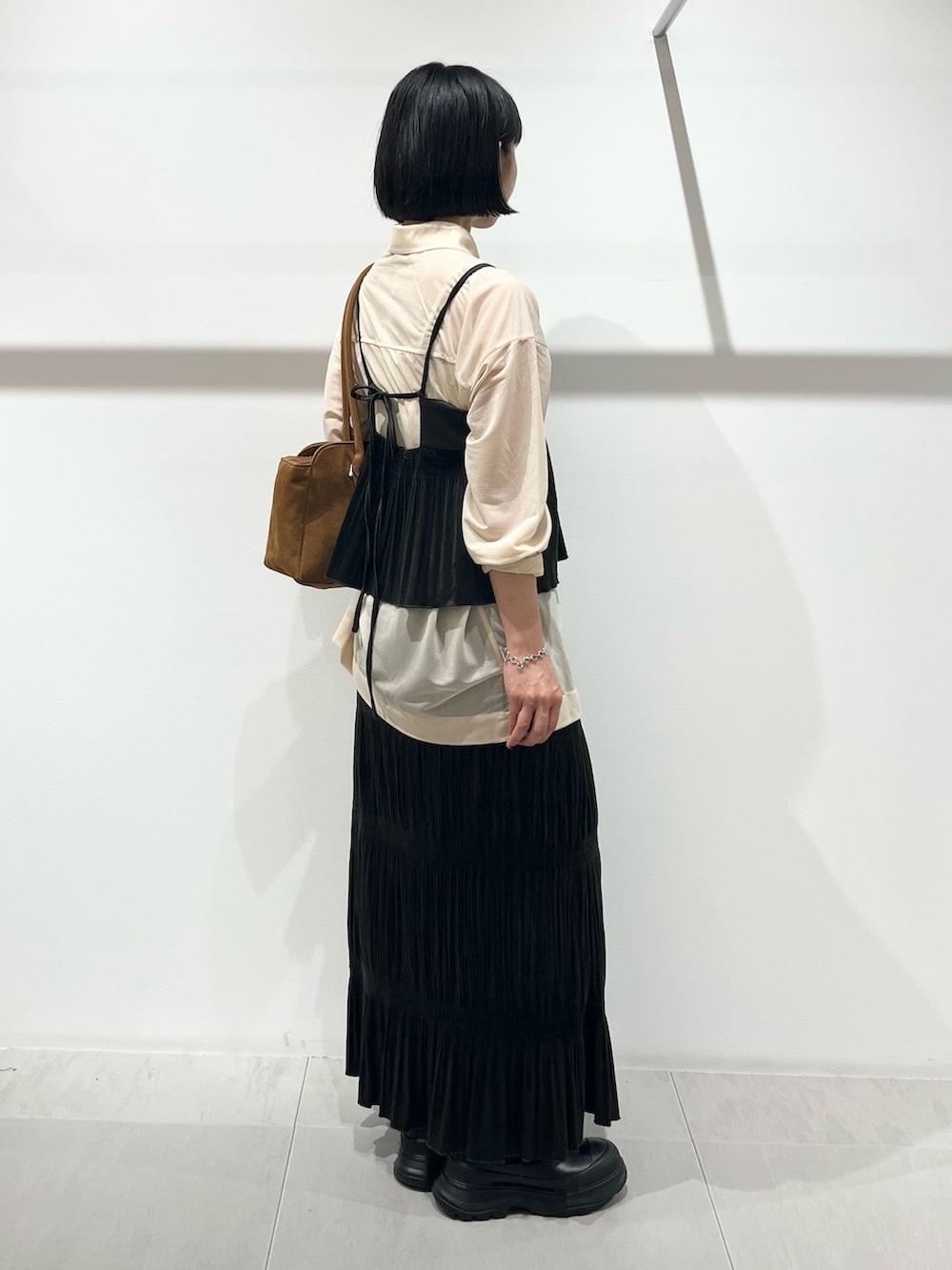 ブラック系のブーツ、ブラウン系のワンピース、ベージュ系のシャツ/ブラウスを着用したレディースの秋コーディネートの2枚目の写真