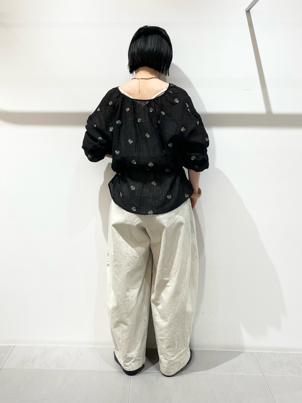ブラック系のシャツ/ブラウス、ホワイト系のその他パンツ、ブラック系のその他シューズを着用したレディースの春コーディネートの3枚目の写真