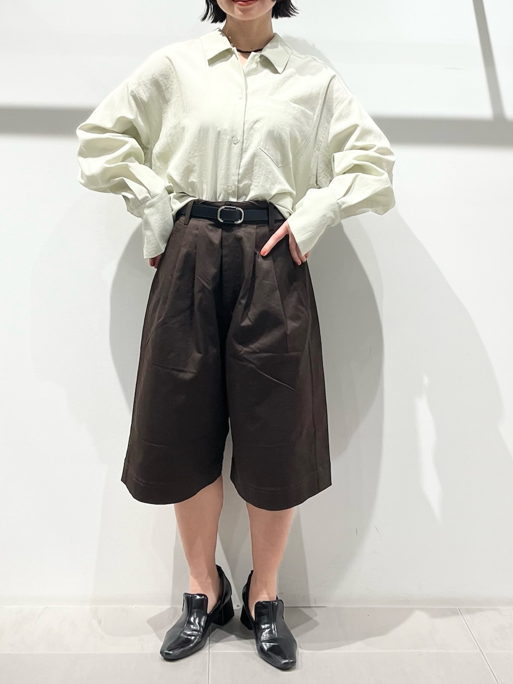 ブラック系のボストンバッグ、ブラック系のパンプス、グリーン系のシャツ/ブラウスを着用したレディースの春コーディネートの7枚目の写真