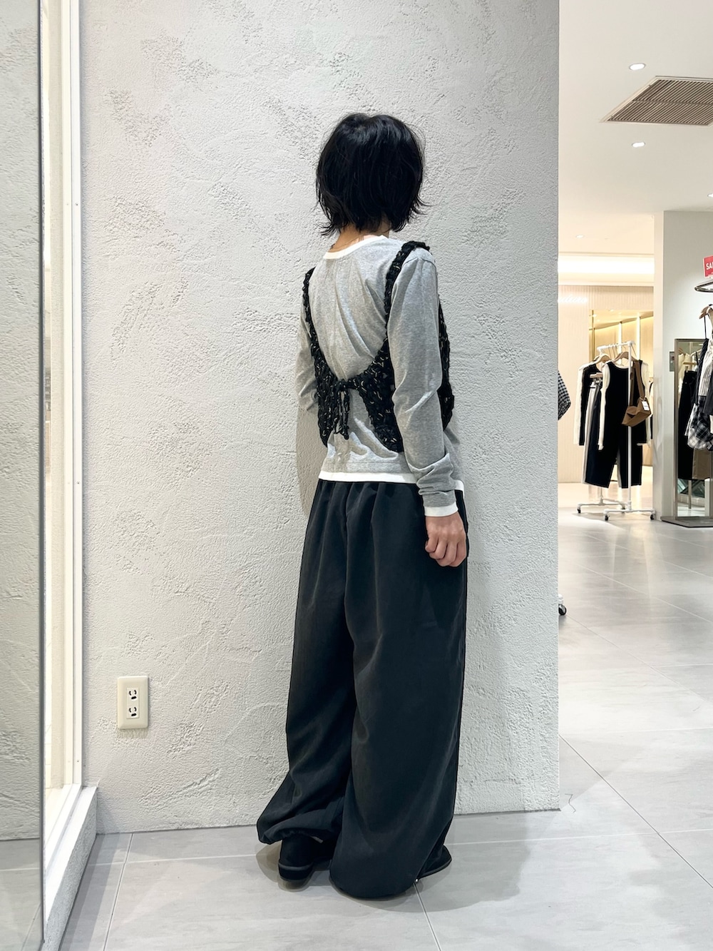 グレー系のTシャツ/カットソー、ブラック系のニット/セーター、グレー系のその他パンツを着用したレディースの秋コーディネートの4枚目の写真
