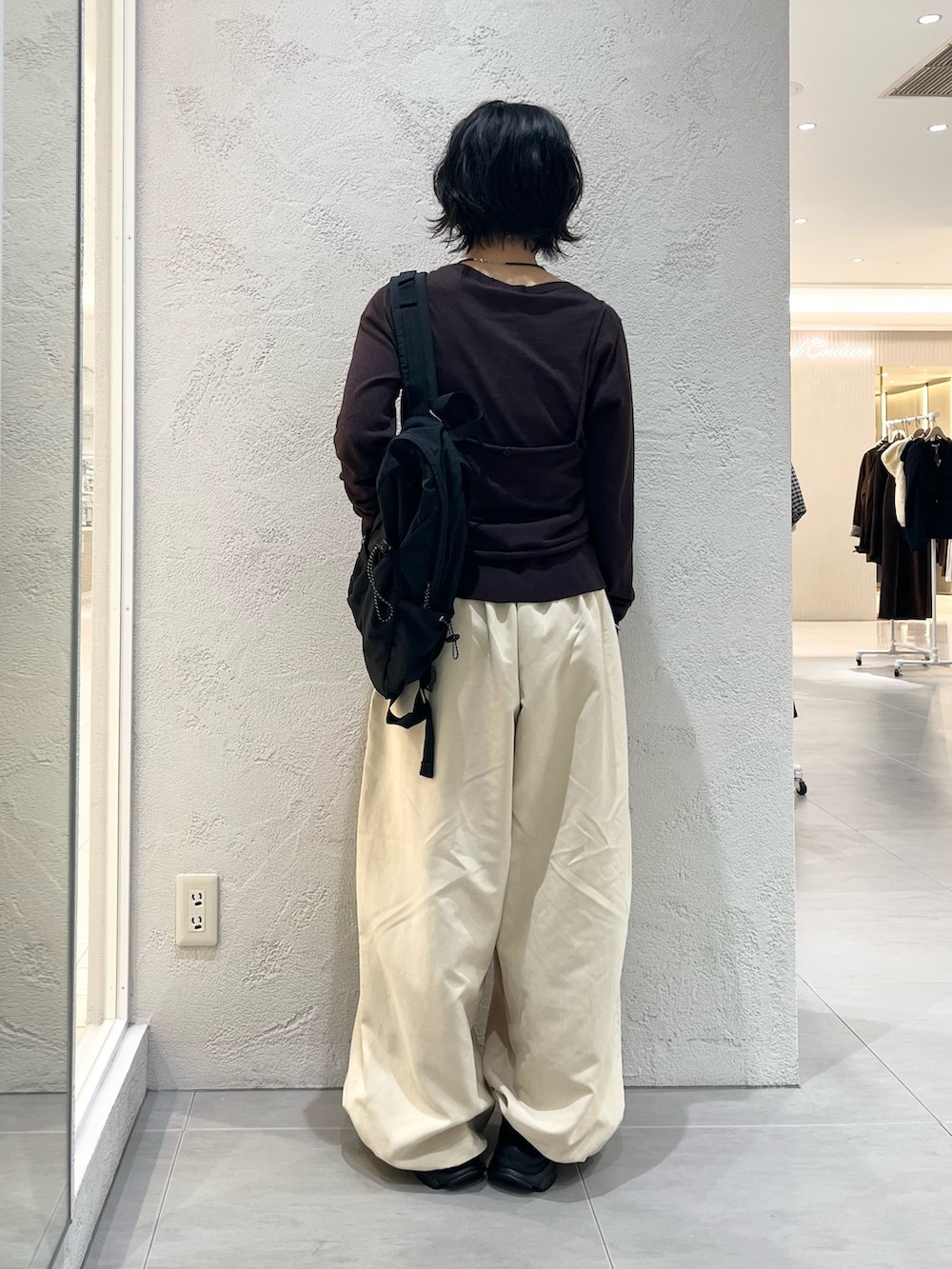 ベージュ系のその他パンツ、ブラウン系のカーディガン/ボレロ、ブラック系のバックパック/リュックを着用したレディースの秋コーディネートの3枚目の写真