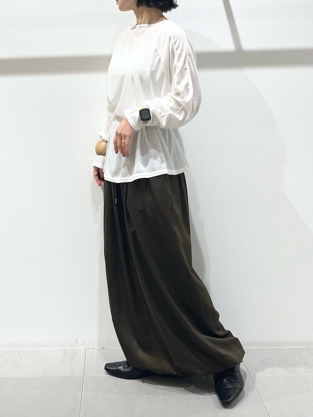 ホワイト系のTシャツ/カットソー、グリーン系のその他パンツ、ブラック系のその他シューズを着用したレディースの冬コーディネートの4枚目の写真