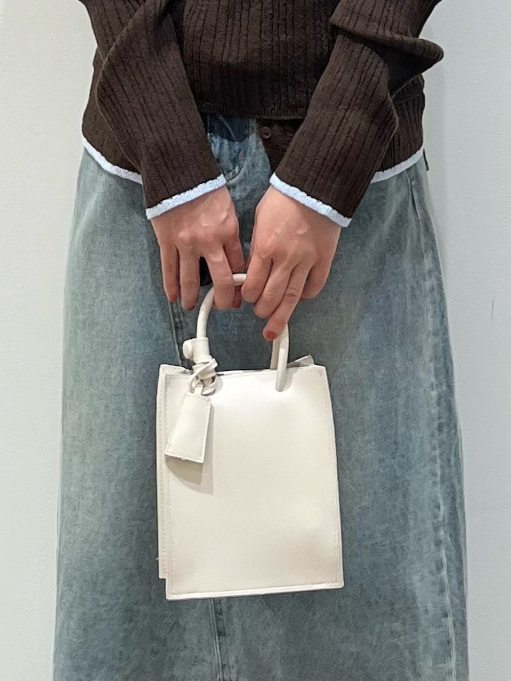 ブラウン系のその他シューズ、ブルー系のスカート、ホワイト系のハンドバッグを着用したレディースの春コーディネートの5枚目の写真