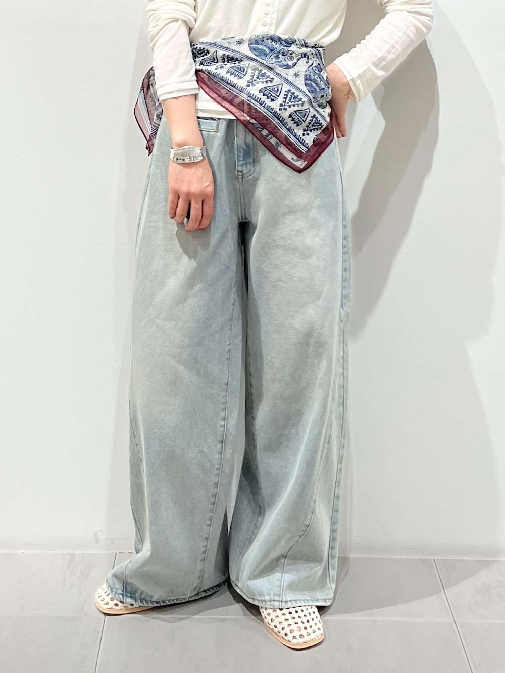 ブルー系のデニムパンツ、ホワイト系のカーディガン/ボレロ、ホワイト系のサンダルを着用したレディースの春コーディネートの6枚目の写真