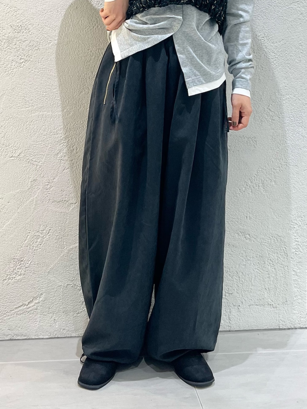 グレー系のTシャツ/カットソー、ブラック系のニット/セーター、グレー系のその他パンツを着用したレディースの秋コーディネートの8枚目の写真