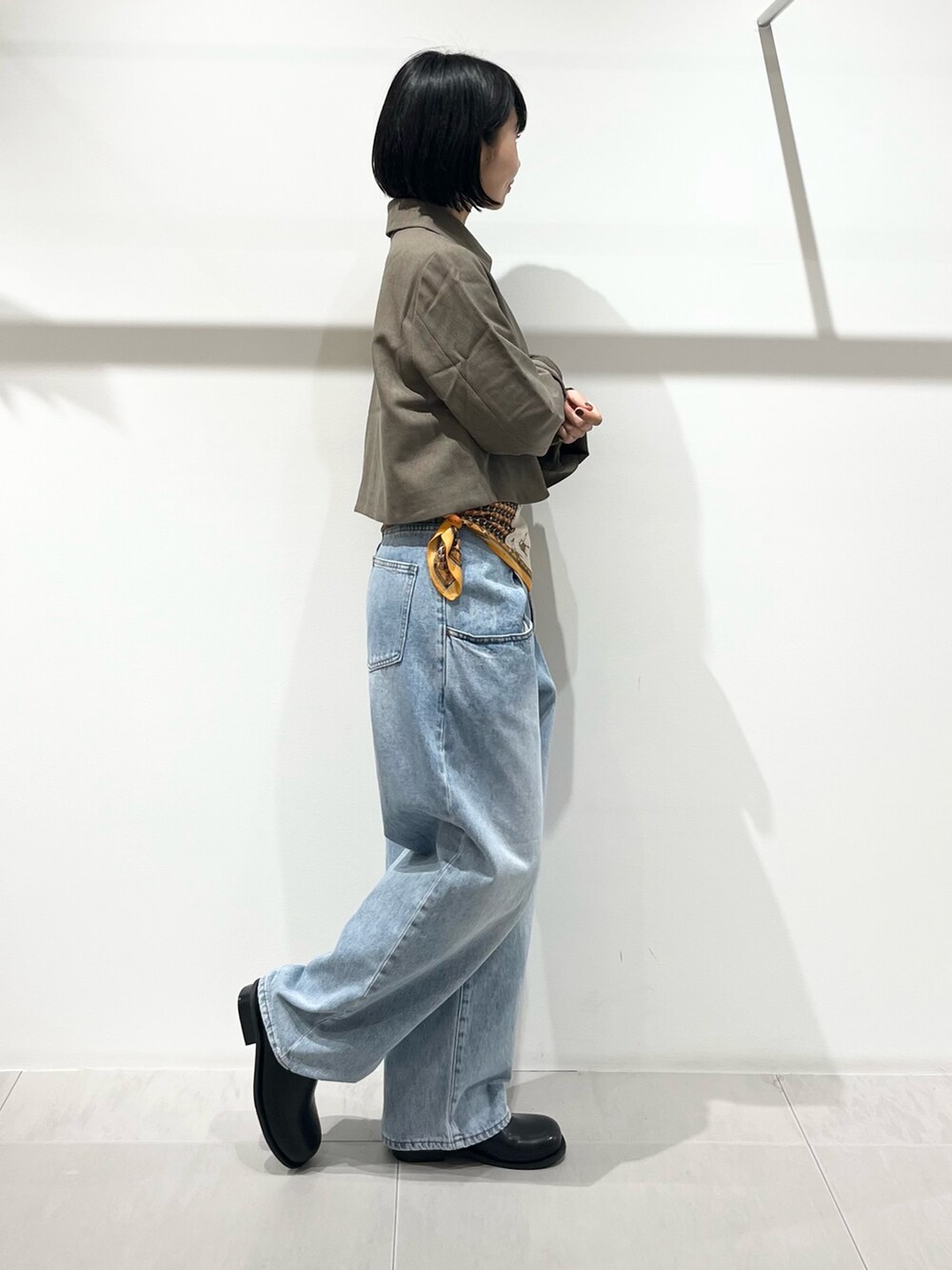 ブルー系のデニムパンツ、ブラック系のその他シューズ、ベージュ系のその他アウターを着用したレディースの秋コーディネートの4枚目の写真