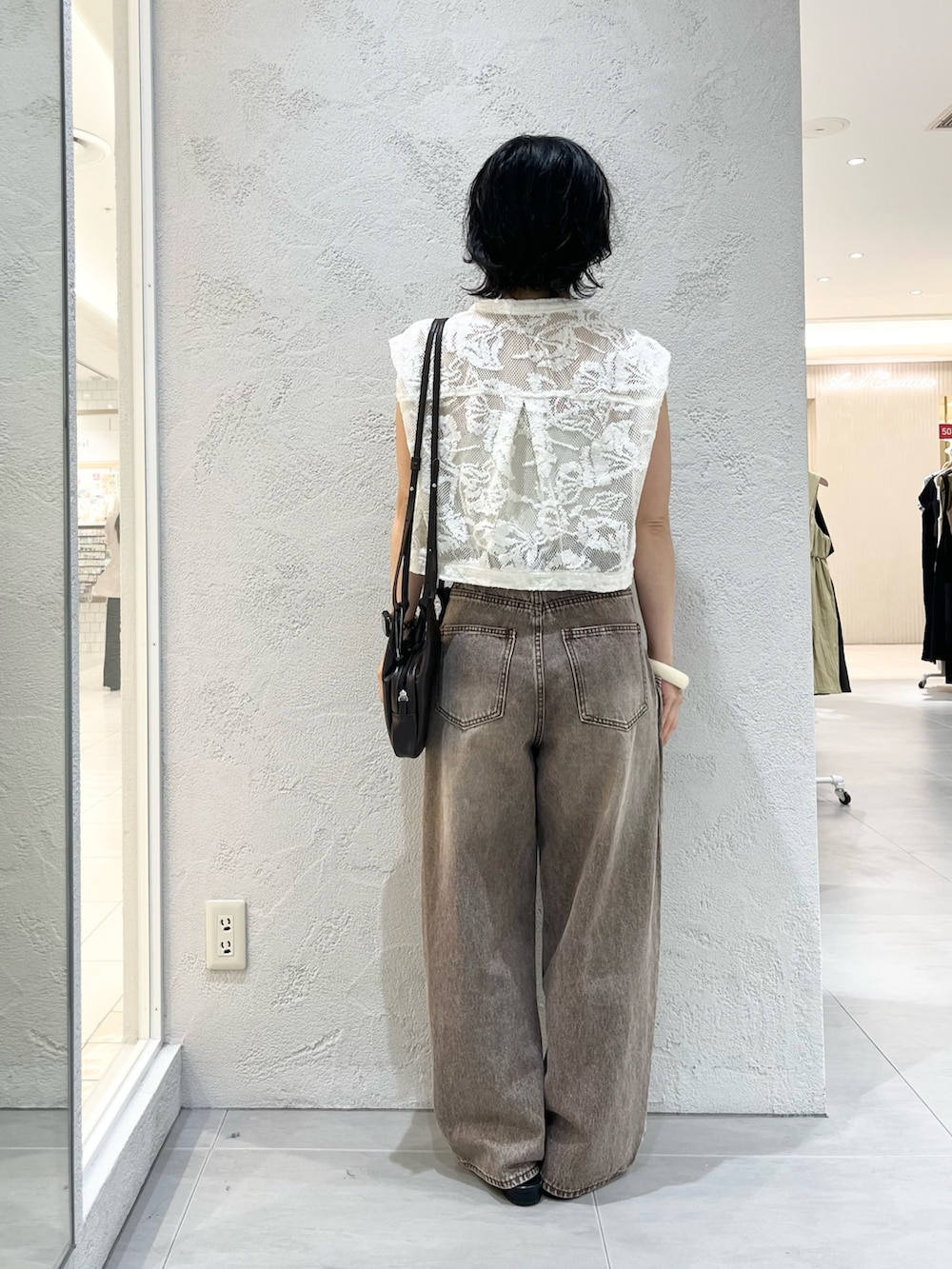 ブラウン系のショルダーバッグ、ホワイト系のシャツ/ブラウス、ブラウン系のデニムパンツを着用したレディースの夏コーディネートの3枚目の写真