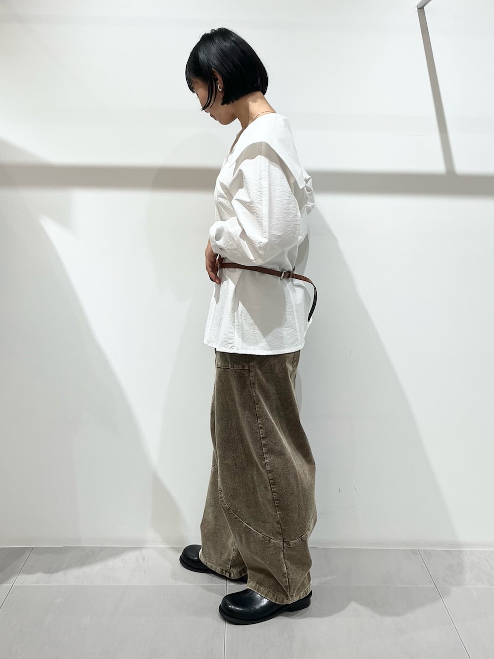 ブラック系のその他シューズ、ブラウン系のその他パンツ、ホワイト系のシャツ/ブラウスを着用したレディースの秋コーディネートの2枚目の写真