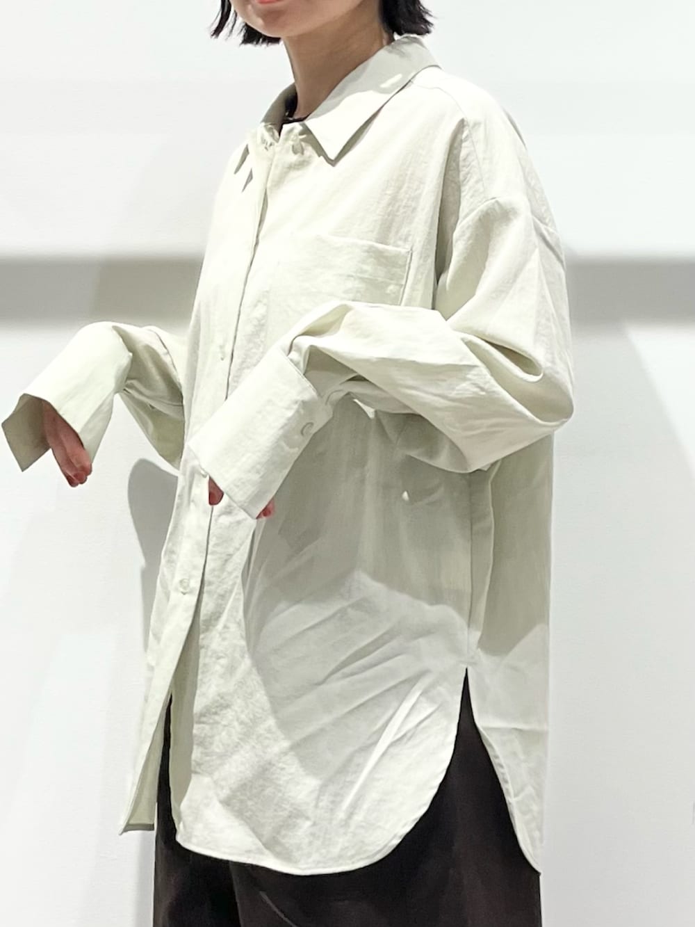 ブラック系のボストンバッグ、ブラック系のパンプス、グリーン系のシャツ/ブラウスを着用したレディースの春コーディネートの6枚目の写真