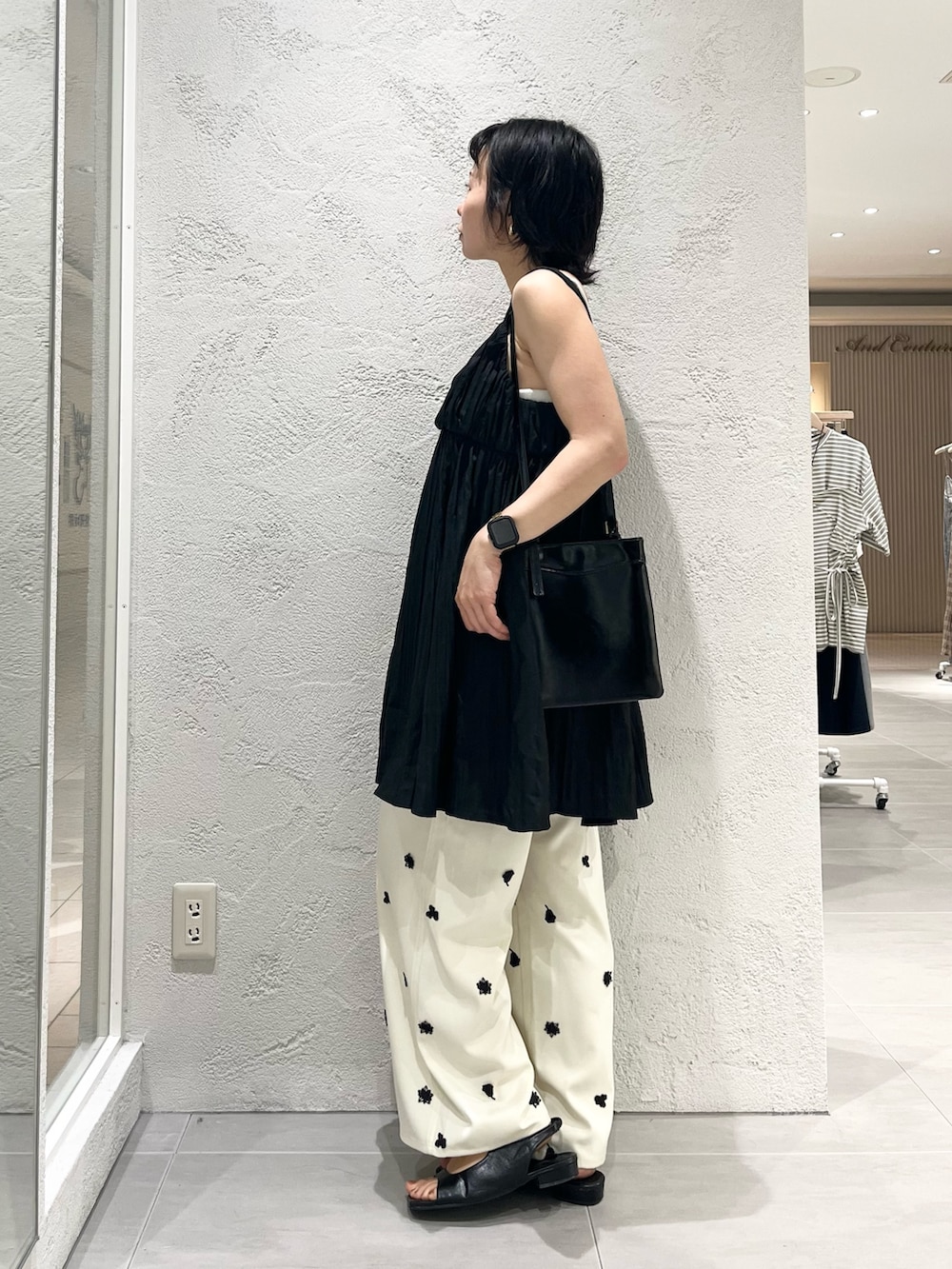 ブラック系のワンピース、ブラック系のサンダル、ホワイト系のその他パンツを着用したレディースの夏コーディネートの2枚目の写真