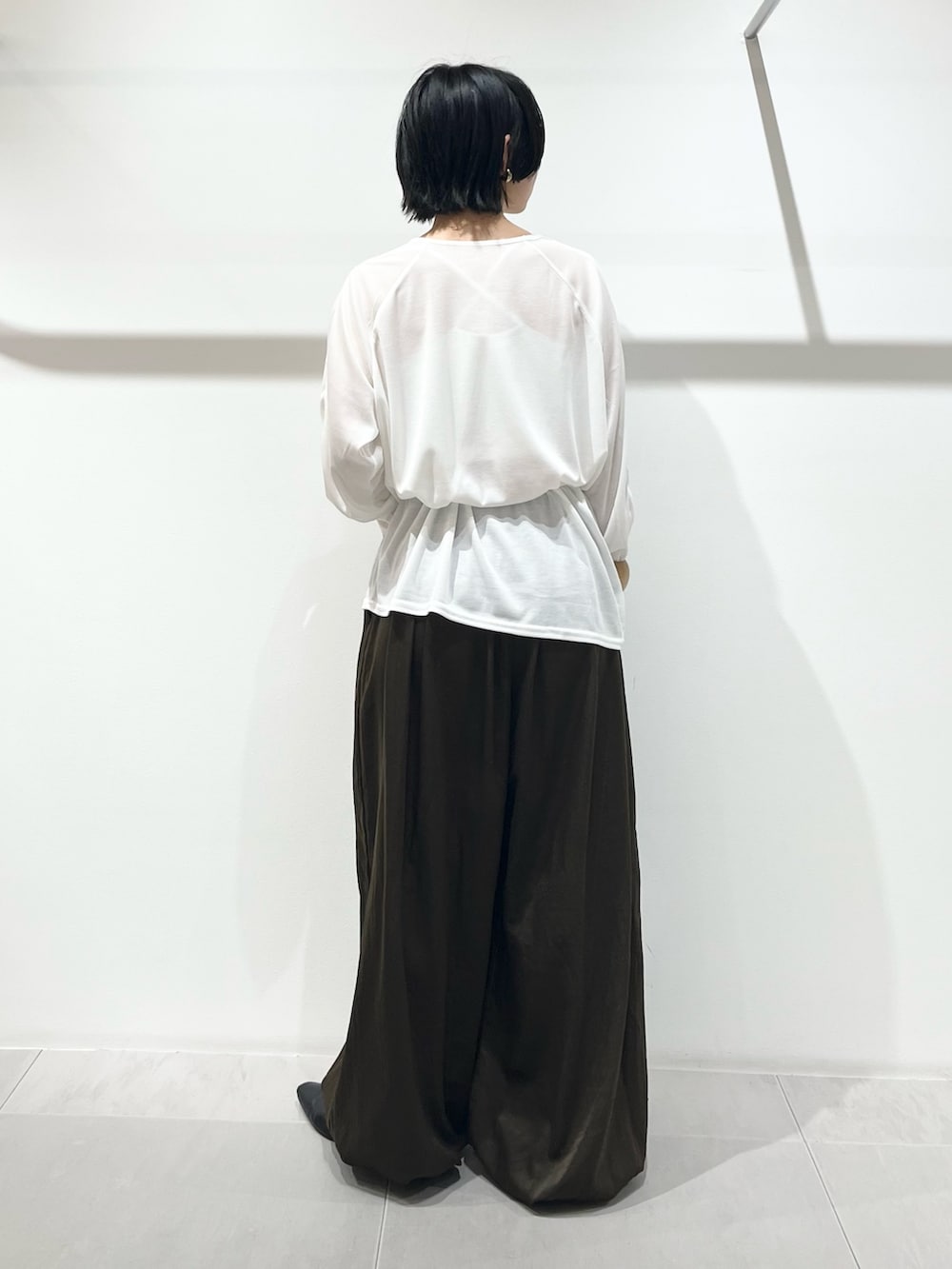 ホワイト系のTシャツ/カットソー、グリーン系のその他パンツ、ブラック系のその他シューズを着用したレディースの冬コーディネートの2枚目の写真