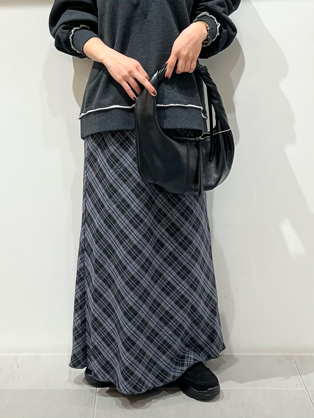 グレー系のTシャツ/カットソー、ブラック系のハンドバッグ、ブルー系のスカートを着用したレディースの秋コーディネートの6枚目の写真