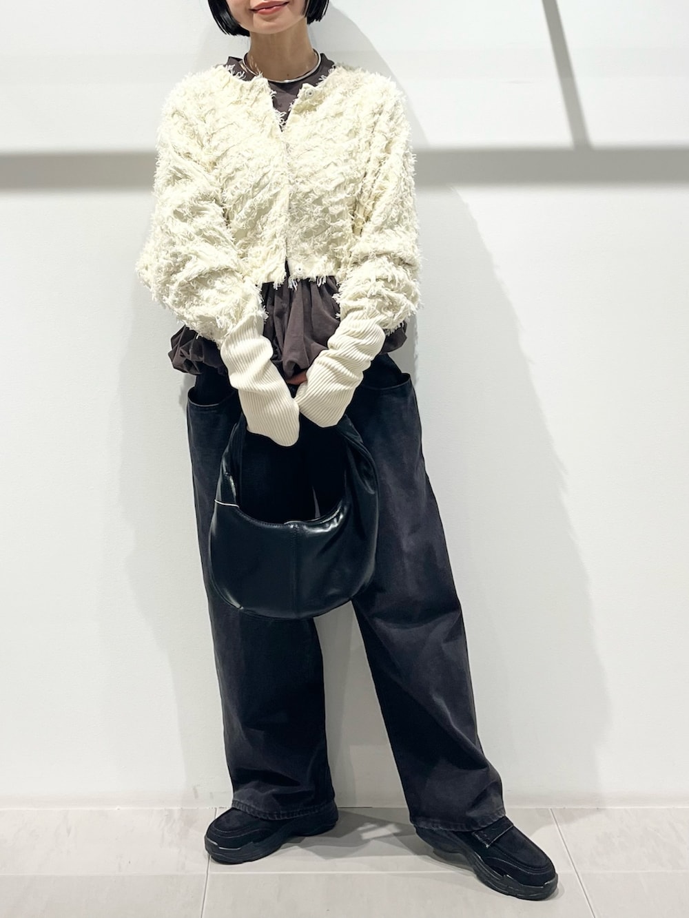 ホワイト系のカーディガン/ボレロ、ブラウン系のTシャツ/カットソー、ブラック系のその他シューズを着用したレディースの冬コーディネートの5枚目の写真