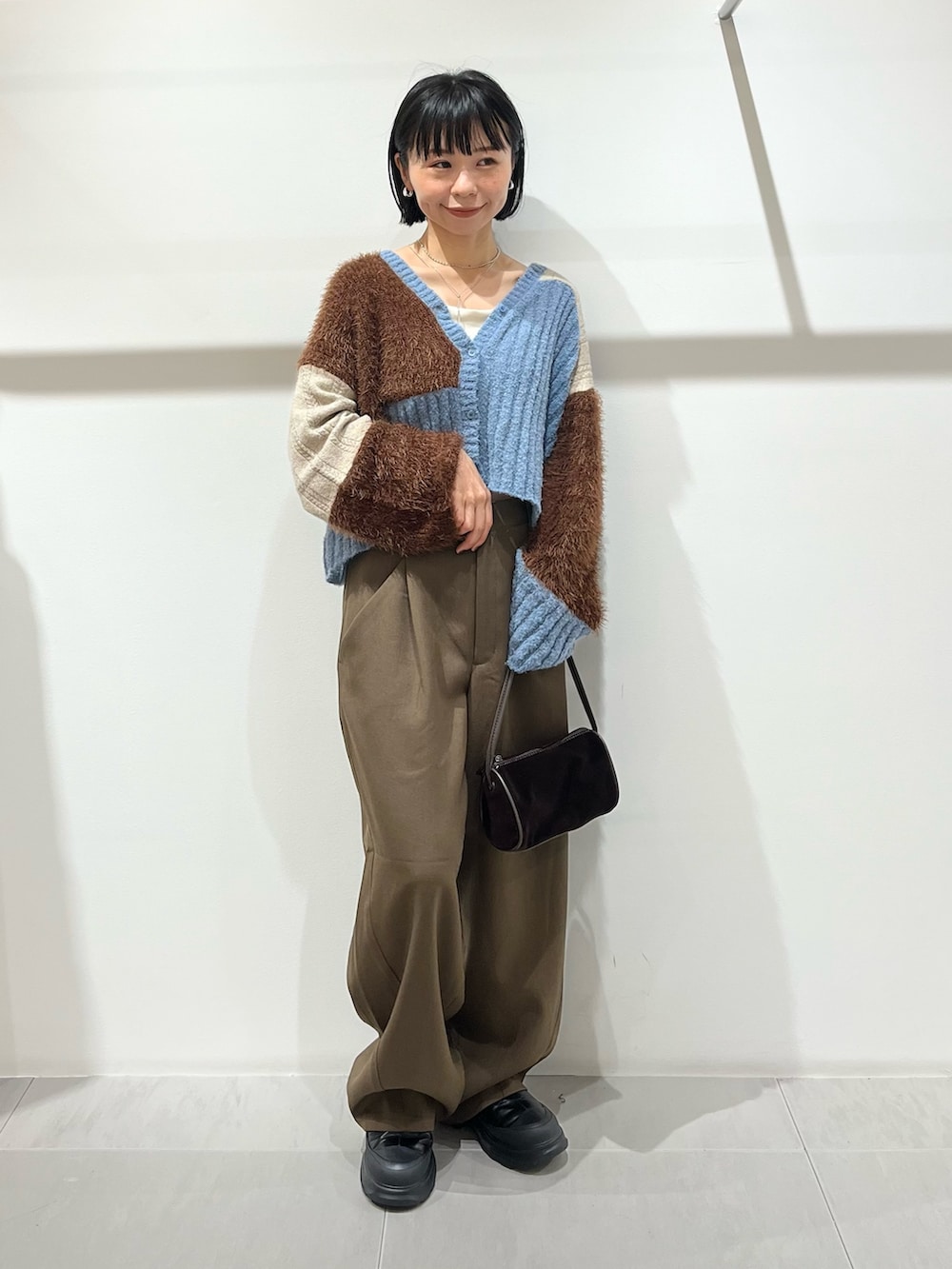 ブラウン系のその他パンツ、ブラック系のブーツ、ブラウン系のショルダーバッグを着用したレディースの秋コーディネートの6枚目の写真