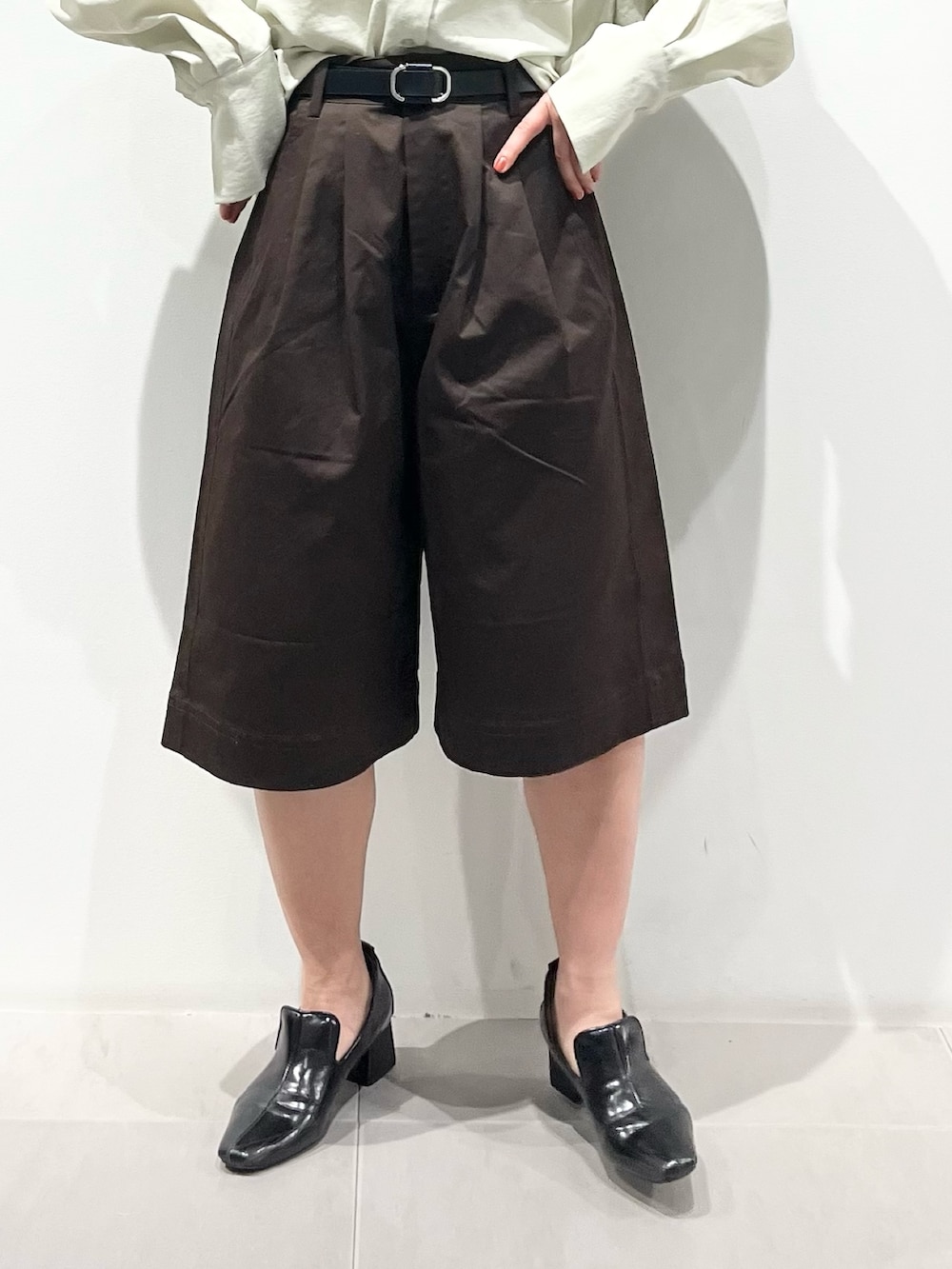 ブラック系のボストンバッグ、ブラック系のパンプス、グリーン系のシャツ/ブラウスを着用したレディースの春コーディネートの5枚目の写真