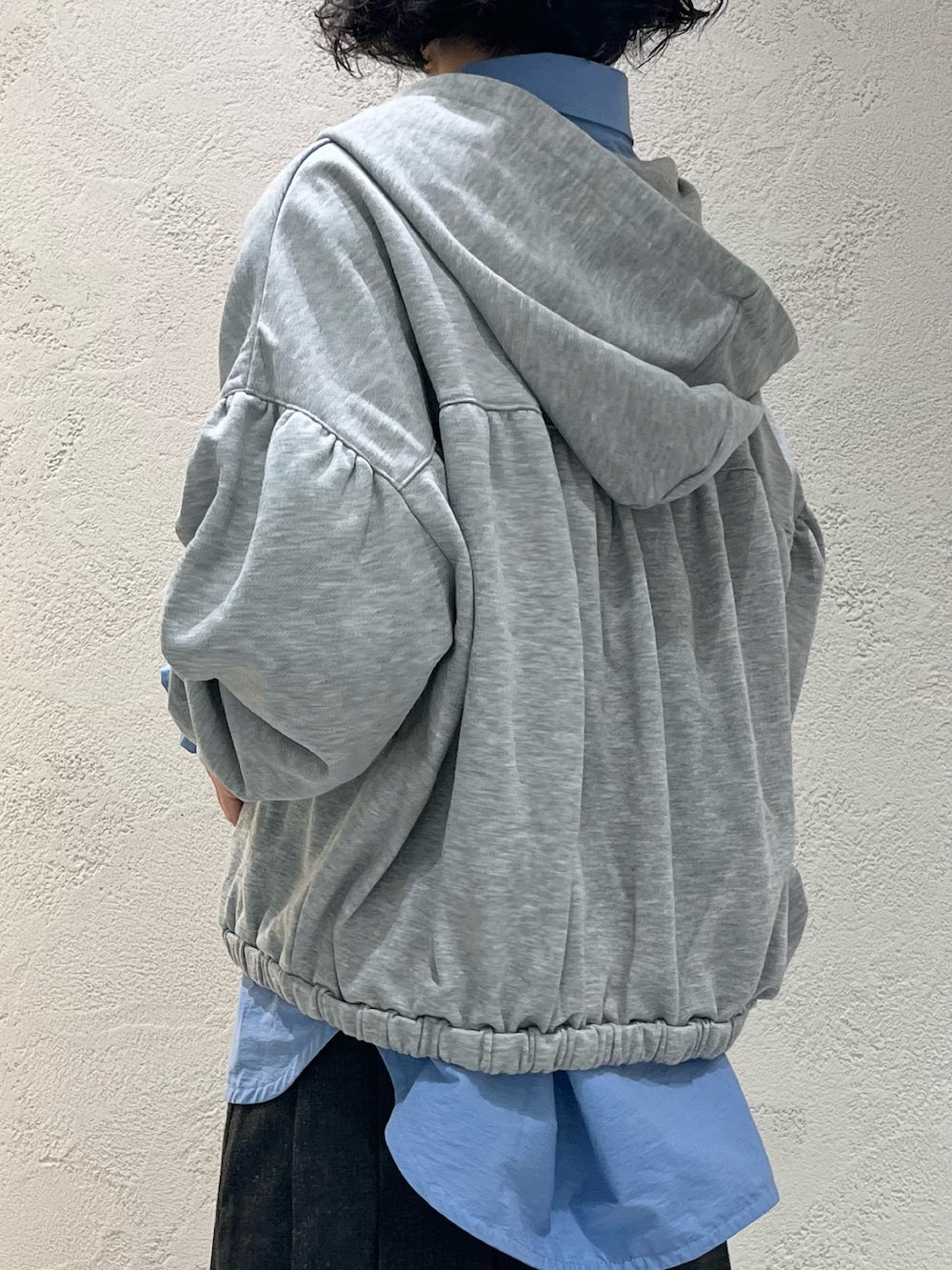 グレー系のスカート、グレー系のパーカー、ブルー系のワンピースを着用したレディースの秋コーディネートの6枚目の写真