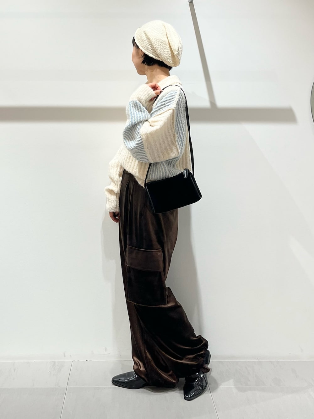 ブラウン系のその他パンツ、ブラック系のショルダーバッグ、ホワイト系のニット/セーターを着用したレディースの秋コーディネートの2枚目の写真