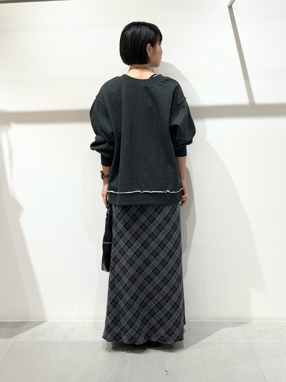 グレー系のTシャツ/カットソー、ブラック系のハンドバッグ、ブルー系のスカートを着用したレディースの秋コーディネートの3枚目の写真