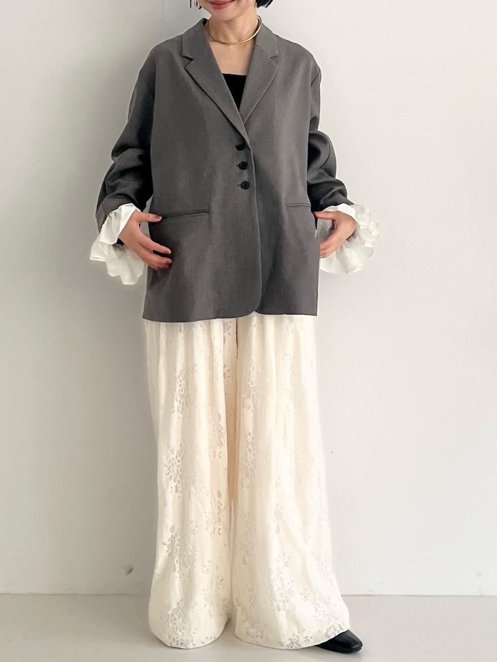 ブラック系のパンプス、グレー系のその他アウター、ホワイト系のその他パンツを着用したレディースの冬コーディネートの7枚目の写真