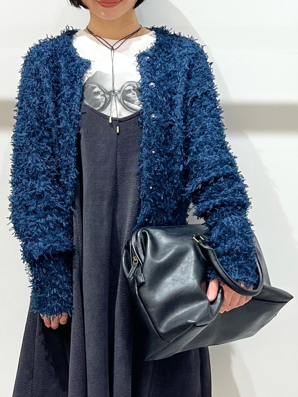 ブルー系のニット/セーター、ブラック系のブーツ、ブラック系のボストンバッグを着用したレディースの秋コーディネートの4枚目の写真